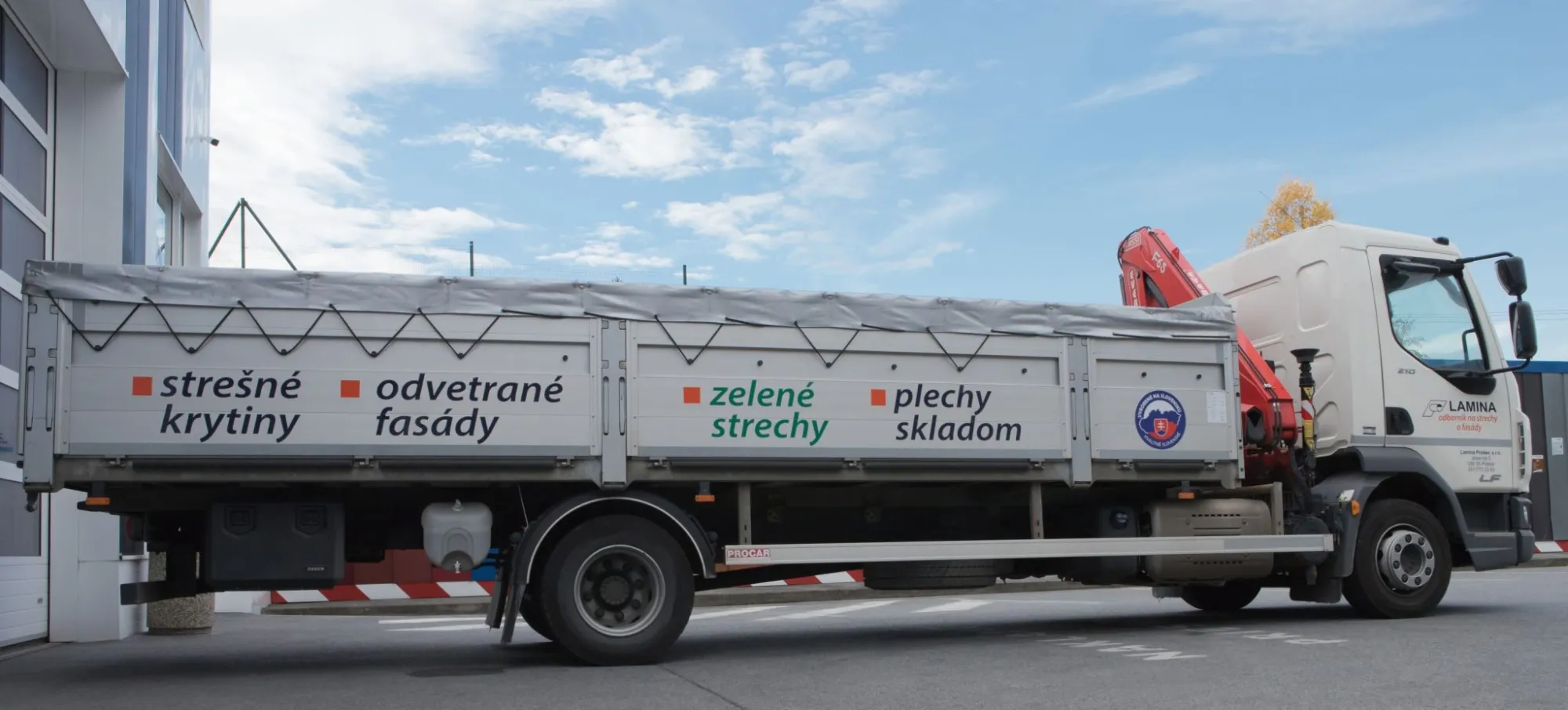 Služby – Doprava zakúpeného tovaru LAMINA PREŠOV strechy fasády plechy odkvapy doplnky Služby - Doprava zakúpeného tovaru nákladné auto LAMINA PREŠOV s nápismi strešné krytiny, odvetrané fasády, plechy skladom, zelené strechy